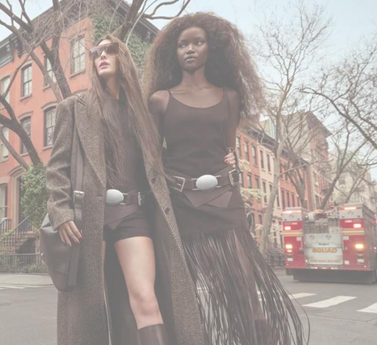 Two women in layered street-style looks on a city sidewalk